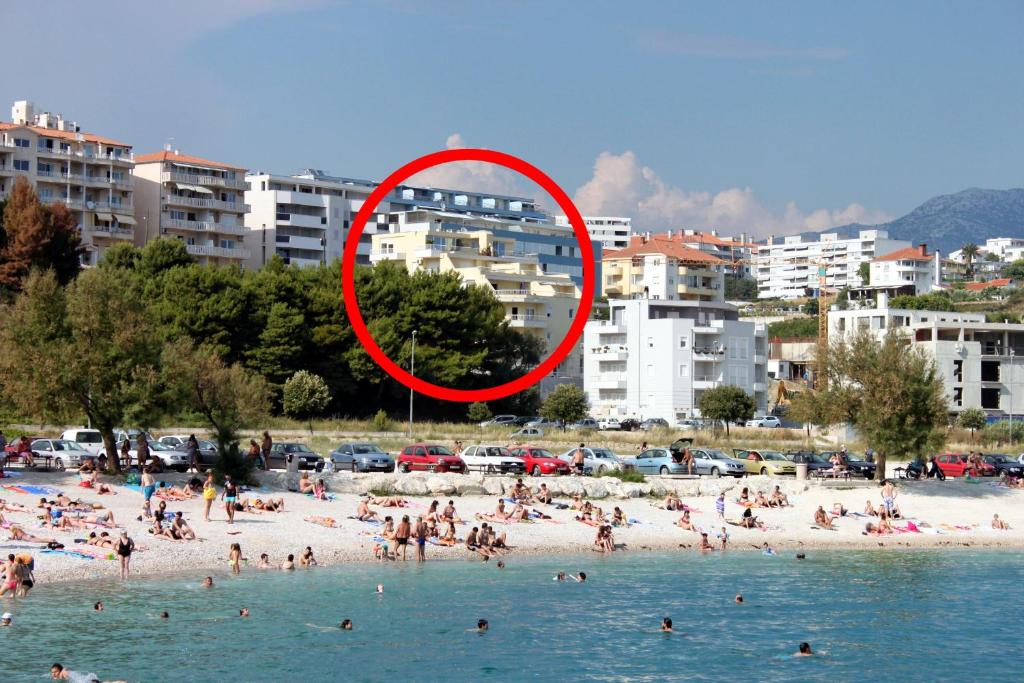 a group of people on a beach with a red circle at Apartments by the sea Split - 7589 in Split