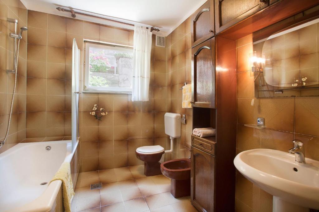 łazienka z wanną, toaletą i umywalką w obiekcie Apartments with parking spaces Rabac, Labin - 7622 w Rabacu