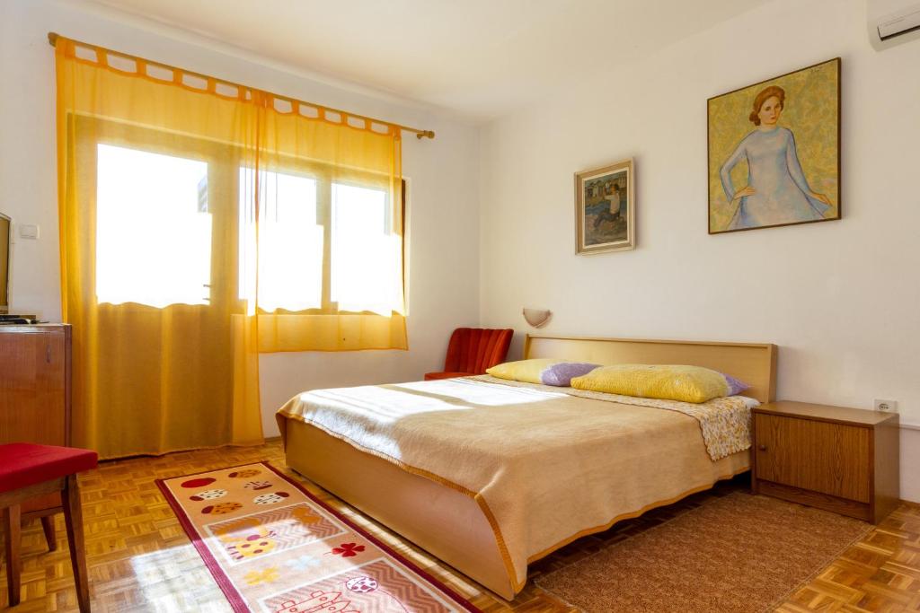 a bedroom with a bed and a window at Apartments by the sea Seget Vranjica, Trogir - 5964 in Seget Vranjica