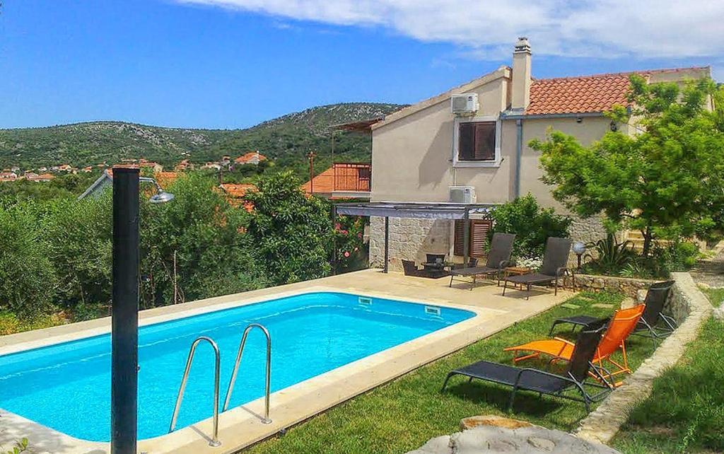 uma piscina em frente a uma casa em Family friendly house with a swimming pool Vinisce, Trogir - 7510 em Vinišće