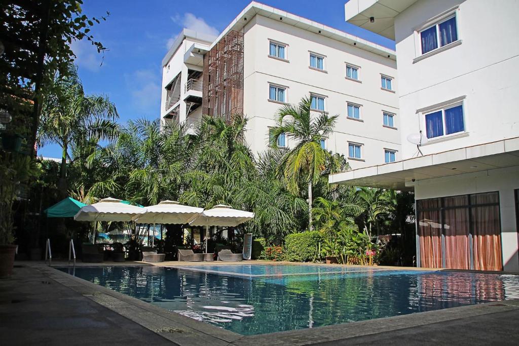 a hotel with a swimming pool in front of a building at Palawan Uno Hotel in Puerto Princesa City