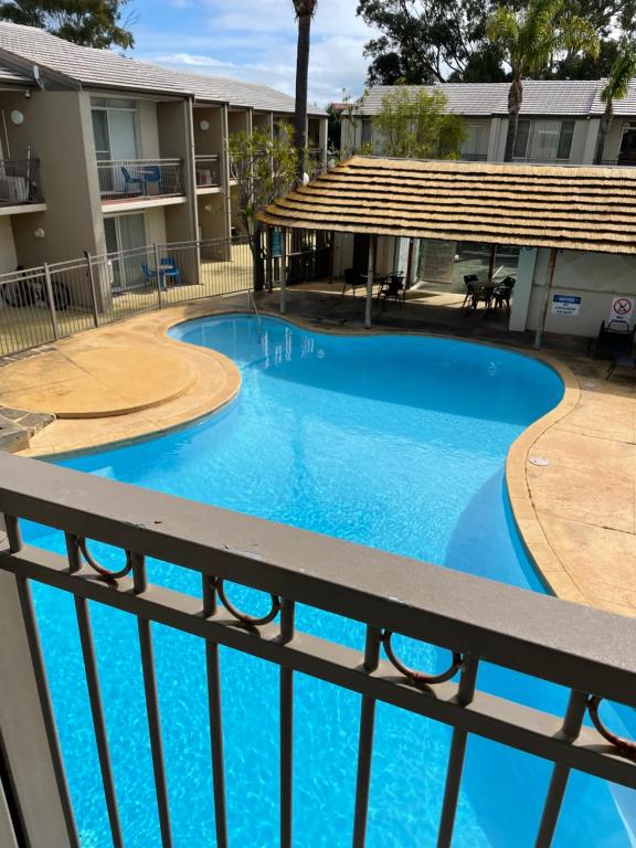 uma vista para uma piscina a partir da varanda de um edifício em Tranquility at Mandurah Apartments em Mandurah