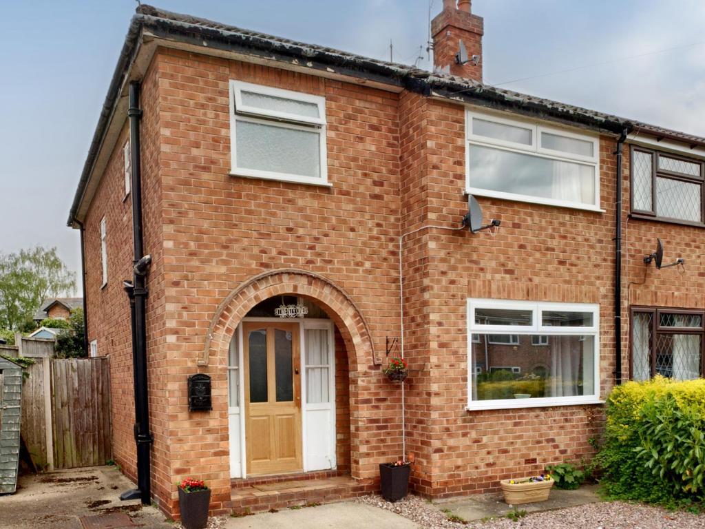 a red brick house with an arched doorway at The Hawthorns in Chester