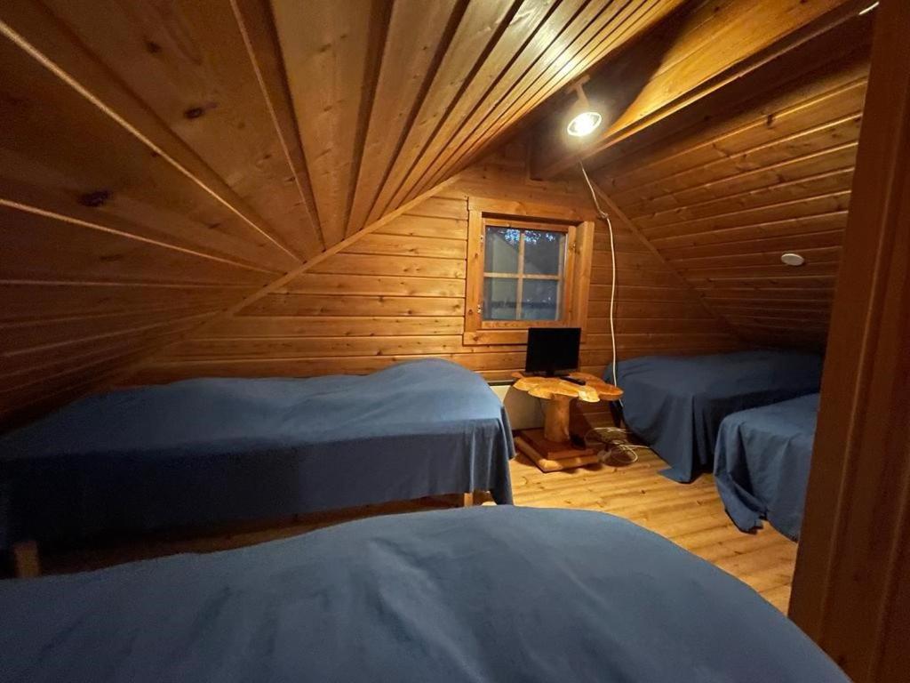 a room with two beds in a wooden cabin at Siljonranta in Muonio