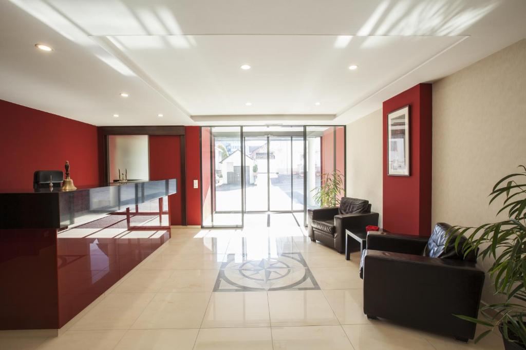 a living room with red walls and a lobby at Aparthotel DeLuxe in Oberkochen