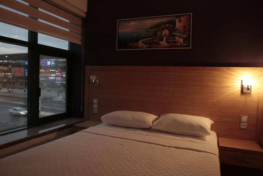 a bed with two pillows in a bedroom with a window at Demir Suite Hotel in Istanbul