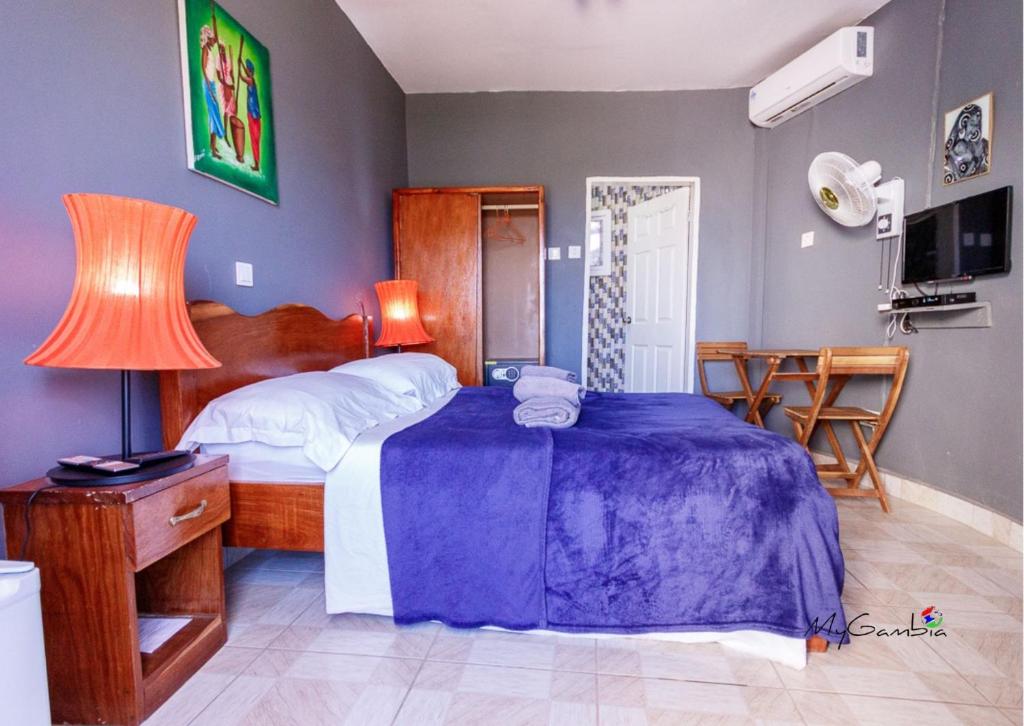 1 dormitorio con 1 cama, 1 mesa y 1 silla en Bojang River Lodge, en Bakau