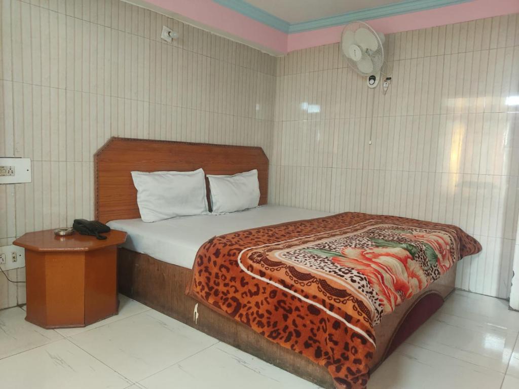 a bedroom with a bed with a leopard blanket on it at Hotel Shubam Banquet & Restaurant By WB Inn in Jammu