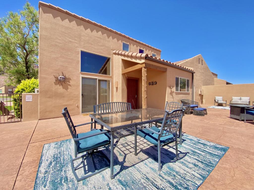 a patio with a table and chairs in front of a house at Rim Village A1 in Moab