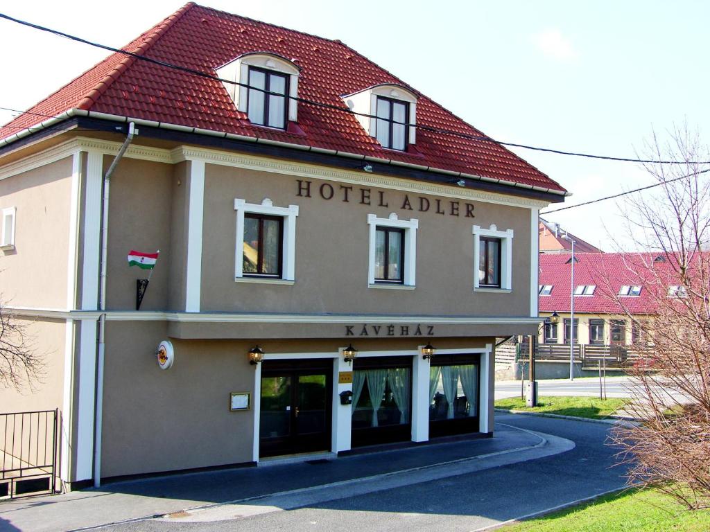 un hotel adler edificio con un cartel en él en Adler Hotel, en Budaörs