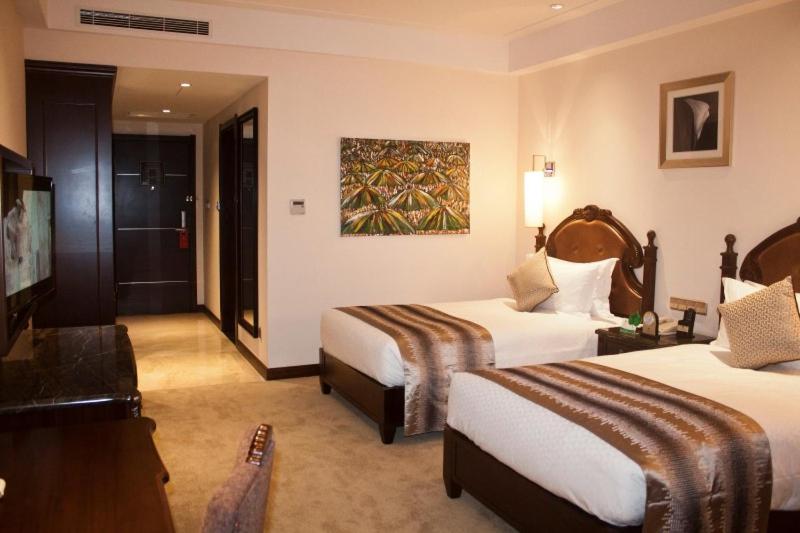 a hotel room with two beds and a television at Amazing Duplex Suite Available in Accra