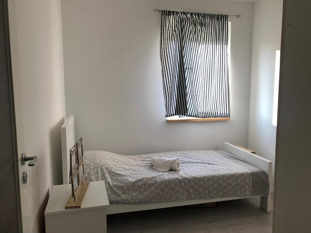 a small bedroom with a bed and a window at Apartment Doris in Tomislavgrad