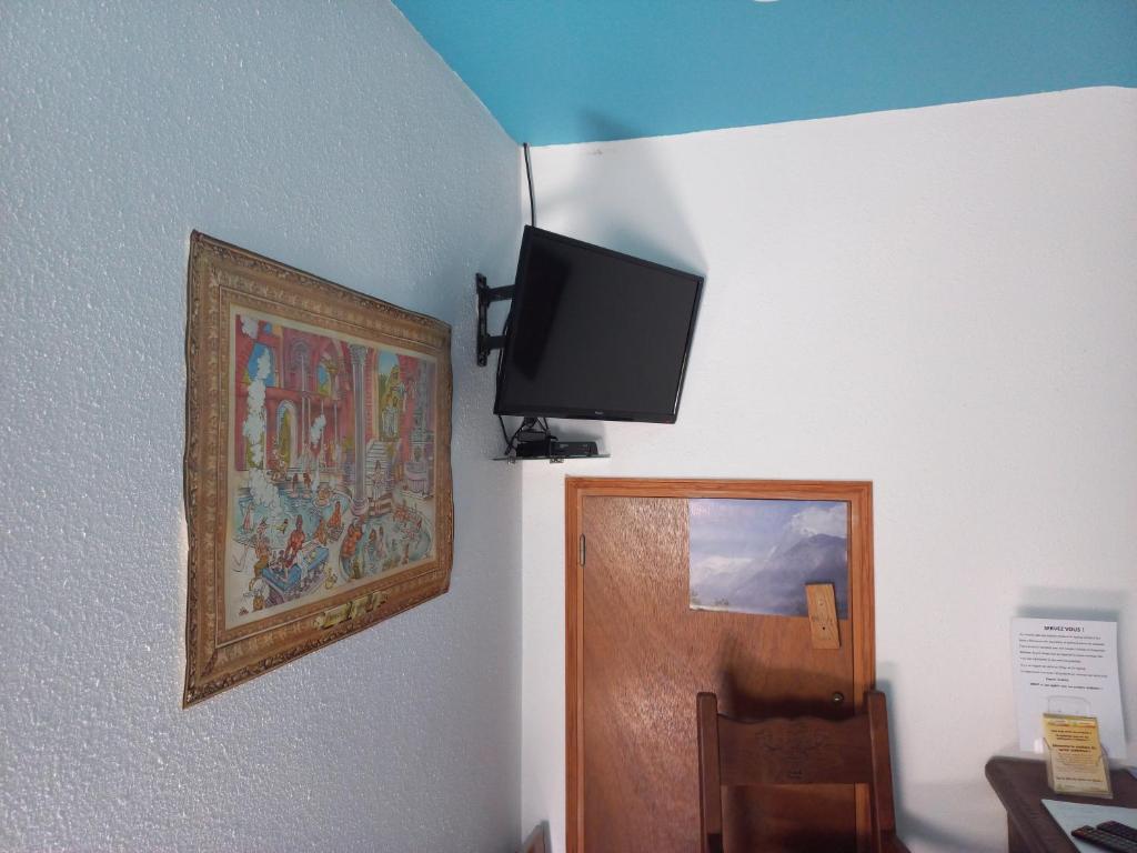 telewizor z płaskim ekranem wiszący na ścianie obok drzwi w obiekcie Namasté w mieście Intres