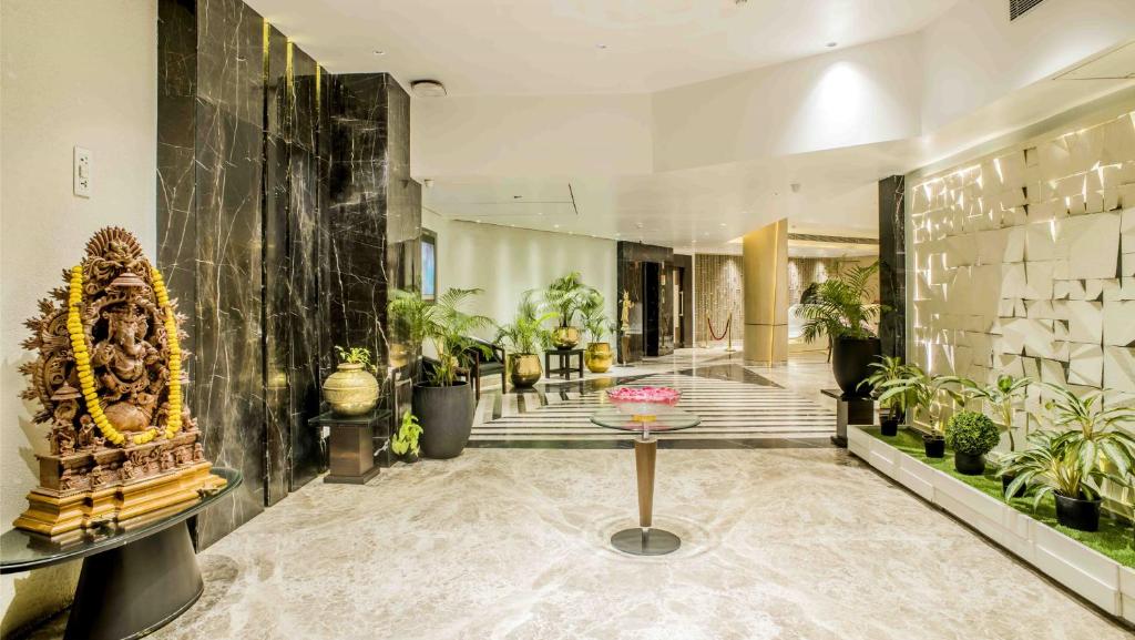 un vestíbulo con una mesa y un montón de plantas en The Citi Residenci Hotel - Durgapur, en Durgāpur