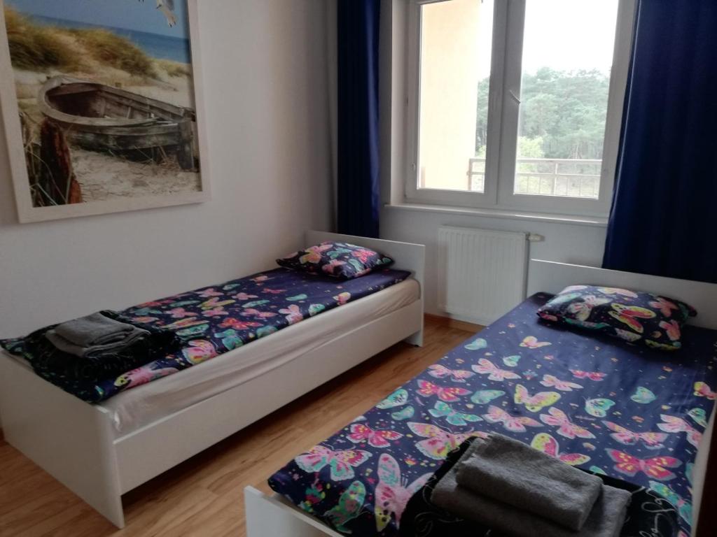 a bedroom with two beds and a window at Apartament Helena in Ustka