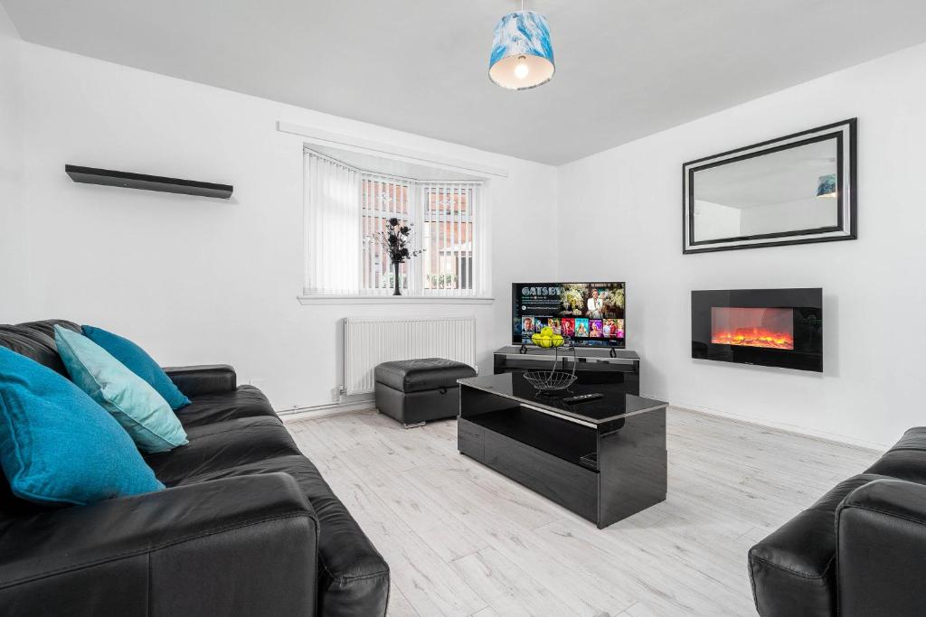 uma sala de estar com um sofá e uma televisão em Modern 4 bedroom home ideal for Contractors, Groups and families ,FREE parking for multiple vehicle's em Birmingham