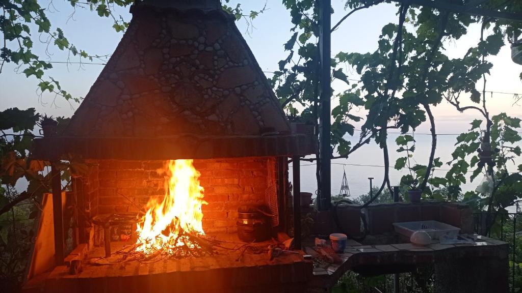 Una chimenea de ladrillo con fuego. en Shenmiter Lukove, en Lukovë