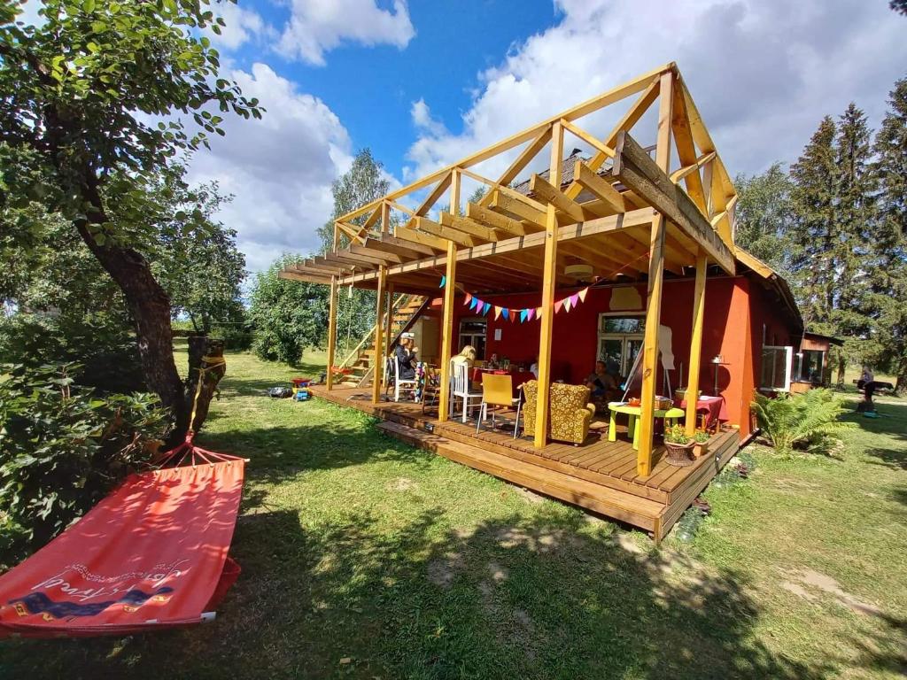 une maison avec une terrasse et un hamac à l'extérieur dans l'établissement Kuberi guesthouse, à Pedja