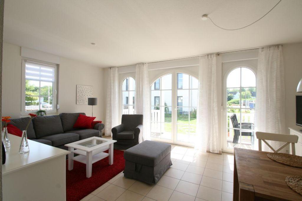 a living room with a couch and a table at Villa Gesine App 01 - Strandkorb in Nienhagen