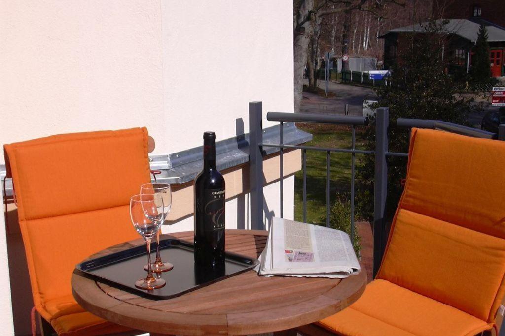 un tavolo con una bottiglia di vino e un bicchiere di Haus Bucheneck App 07 a Graal-Müritz