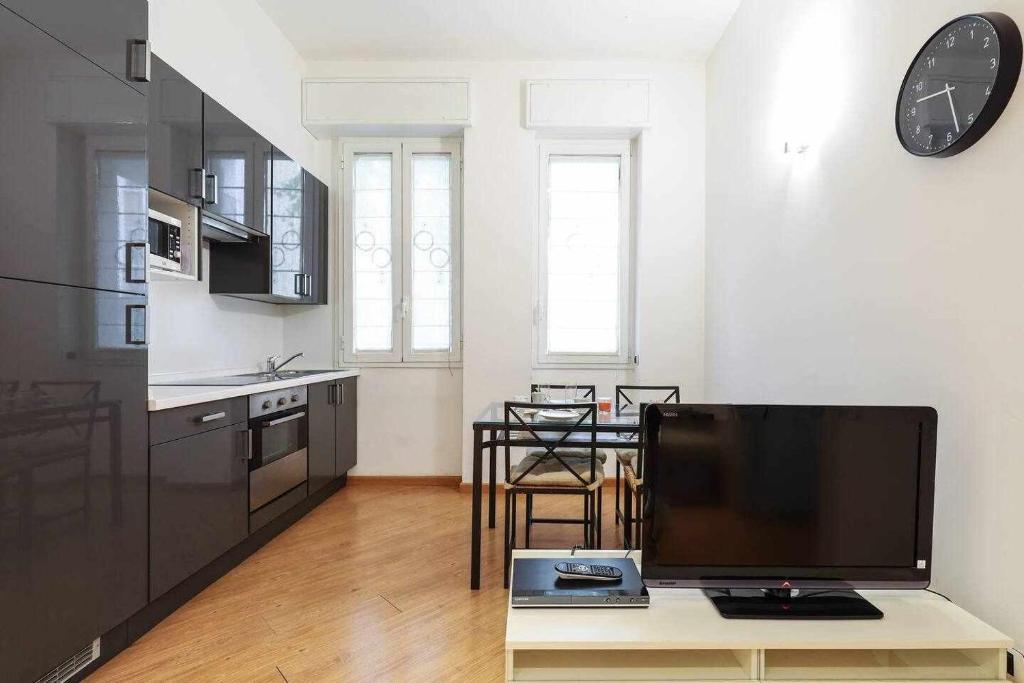 a living room with a tv and a kitchen at SV18C Charming modern flat S Ambrogio in Milan