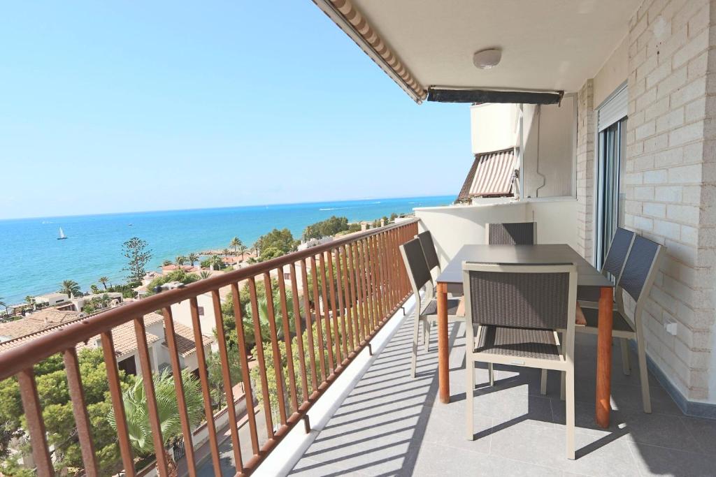 a balcony with a table and chairs and the ocean at 069 - Panorama 001 - comfortHOLIDAYS in Santa Pola