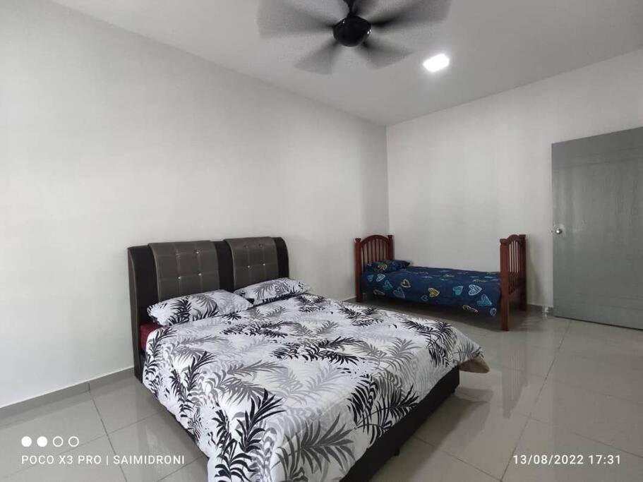 a bedroom with a bed and a ceiling fan at Sehmi's Homestay, Pagoh, Muar in Pagoh