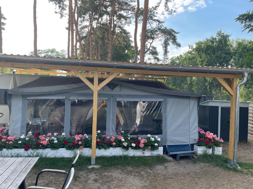 a gazebo with flowers and a table at Prestige Camping Brandenburg in Plaue