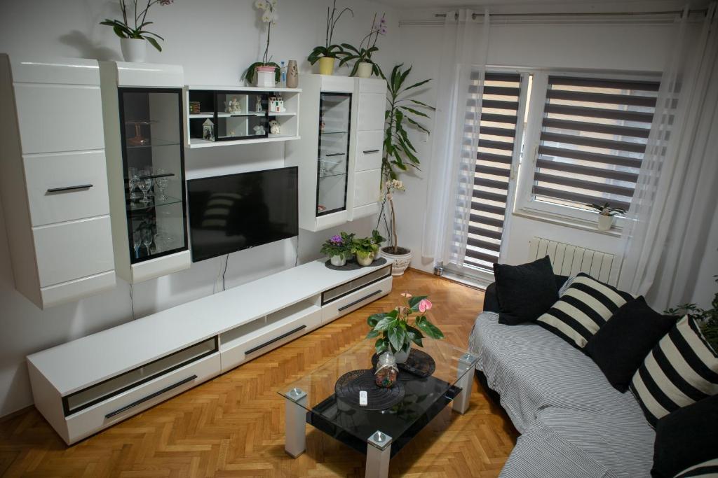 een woonkamer met een witte bank en een flatscreen-tv bij Viollet in Omiš
