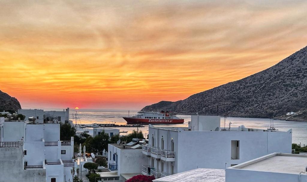 a cruise ship in the ocean at sunset at Theodora Rooms in Kamarai