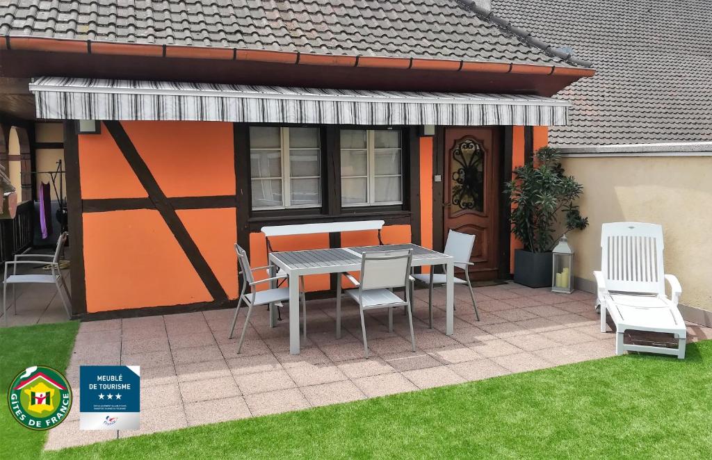 a patio with a table and chairs next to a house at Gîte avec SPA au cœur du vignoble d'Alsace in Sigolsheim