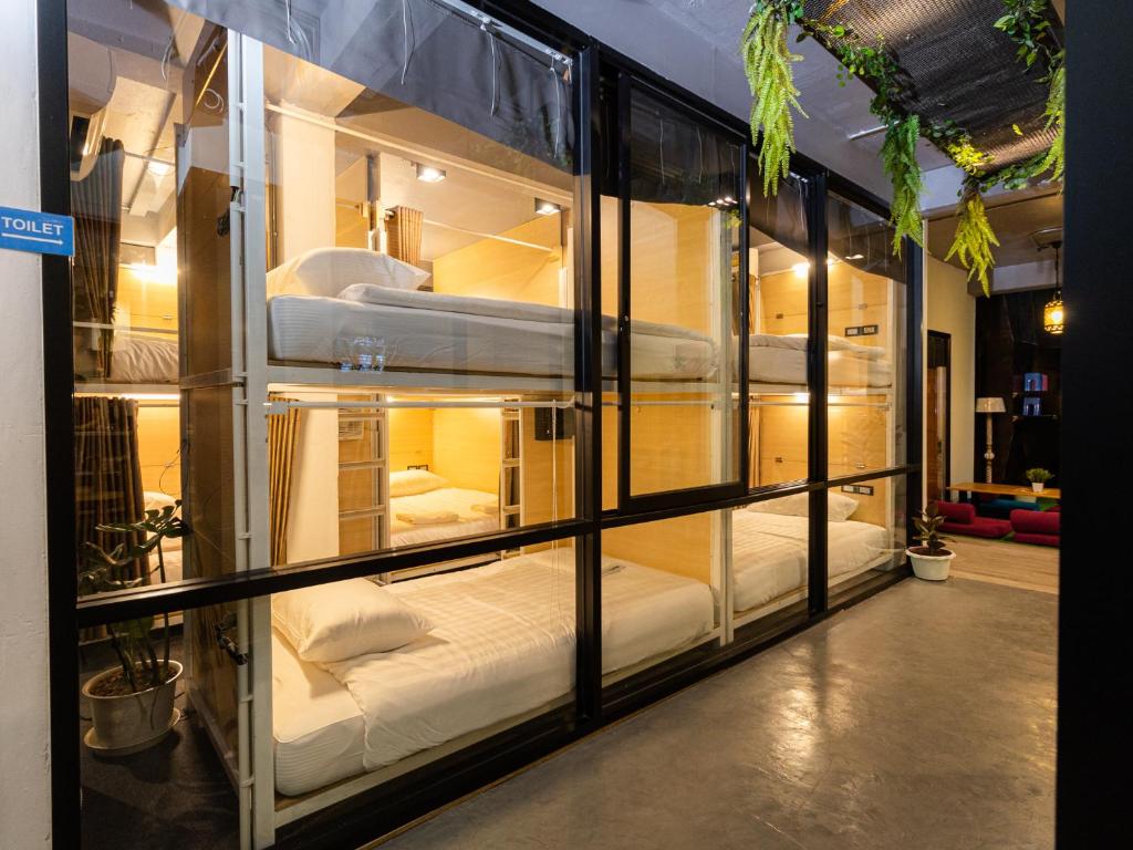 a room with a bunch of beds in a display case at Khao San Social Capsule Hostel in Bangkok