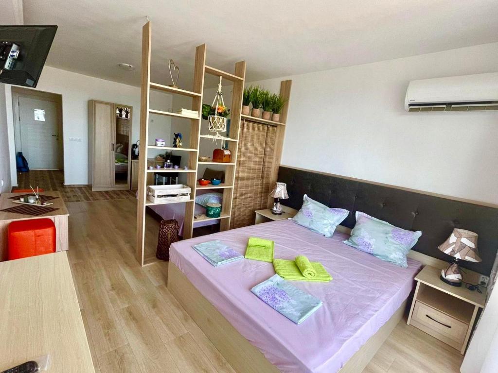 - une chambre avec un lit violet et 2 oreillers jaunes dans l'établissement Perla Del Mar Studio PANORAMA First line, à Lozenets