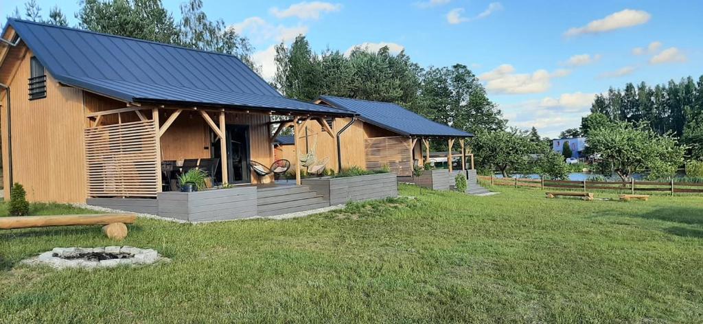 uma cabana de madeira com um telhado azul num campo em Sominkowe Wzgórze em Sominy