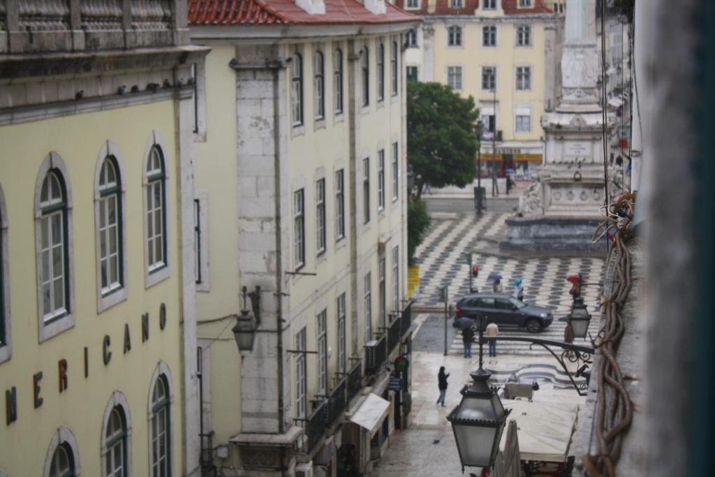 a view of a city street with buildings and a car at Pensao Residencial Estrela do Mondego in Lisbon