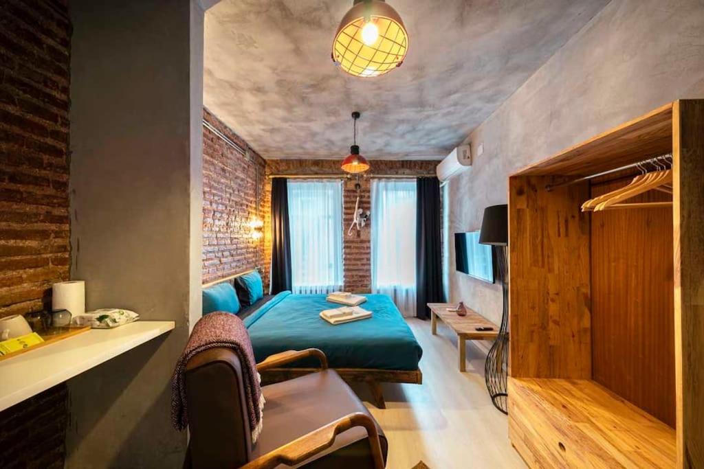 a bedroom with a green bed and a brick wall at Classy Furnished Studio in The Heart of Karaköy ( Karakoy 1 ) in Istanbul