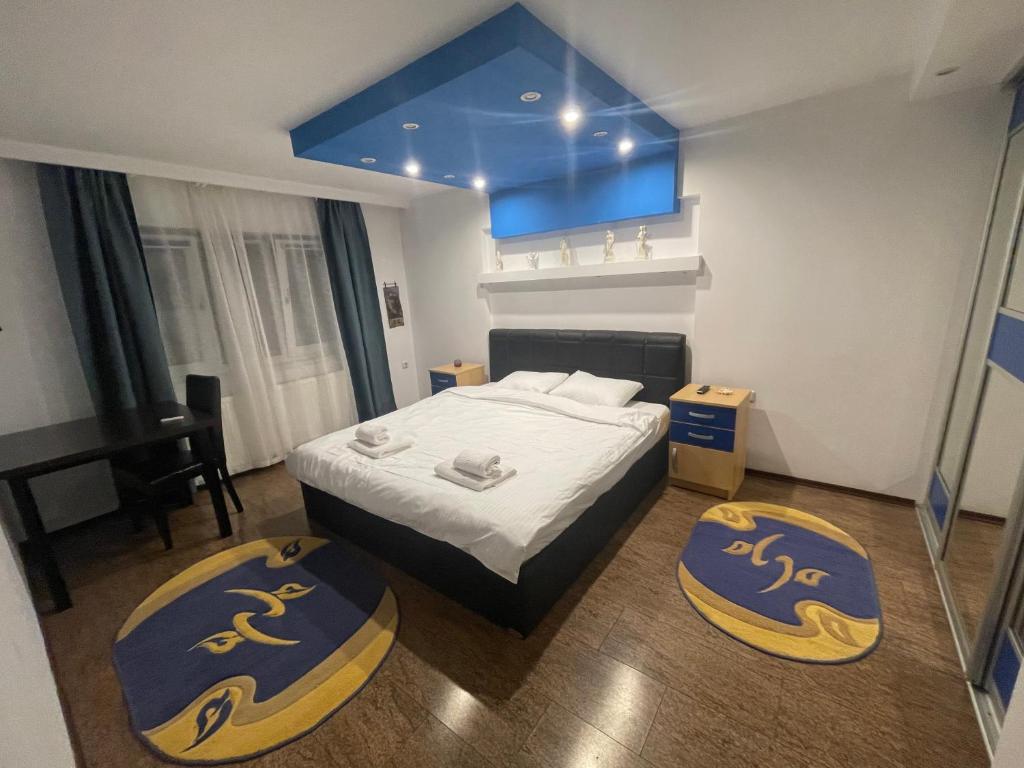 a bedroom with a bed and two ottomans at Apartament Retreat in Drăgăşani