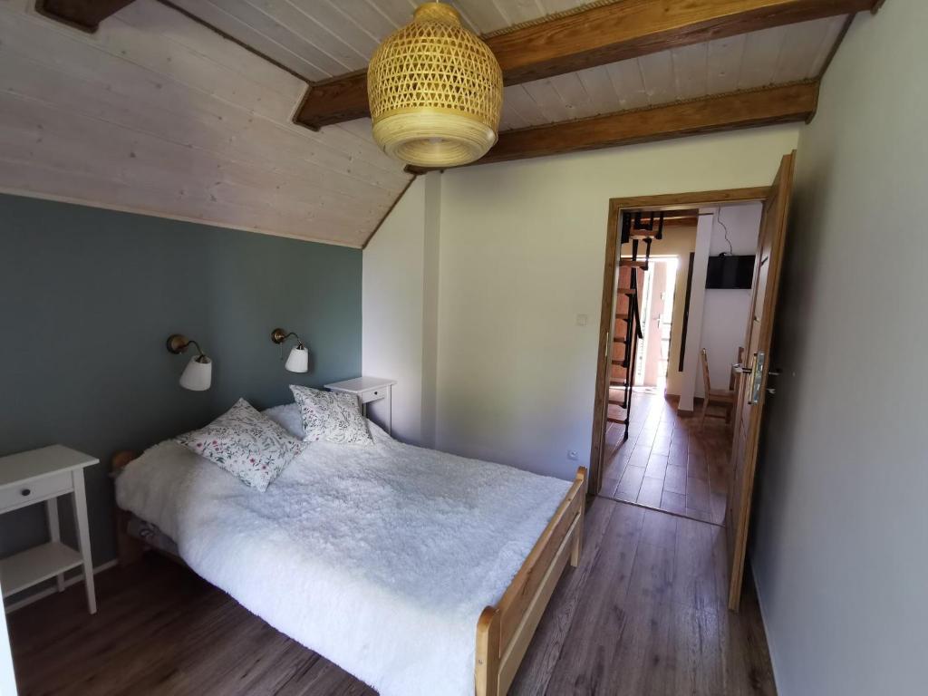 um quarto com uma cama branca e piso em madeira em Apartament Jaśmin em Polańczyk