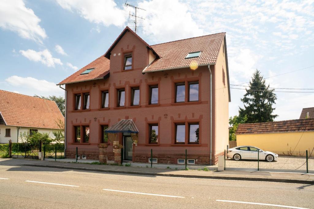 a large red building with a car parked in front of it at Gemütlich 6 in Wissembourg