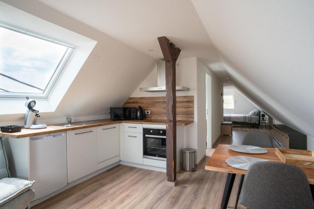 a kitchen with white cabinets and a table and a window at Gemütlich 7 - Appartement cosy climatisé in Wissembourg