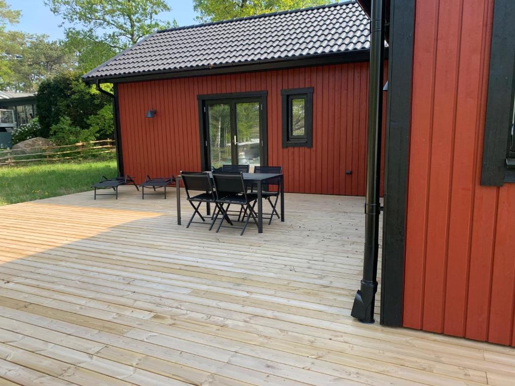 a patio with a table and chairs next to a red building at Stugcentralen F-16B in Halmstad