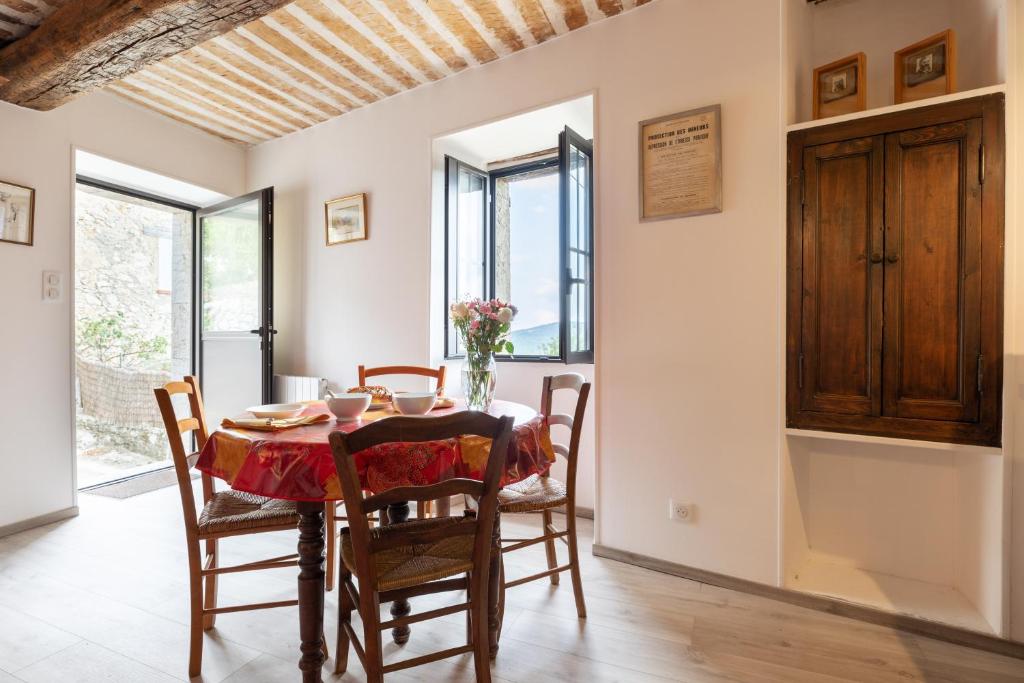 a kitchen and dining room with a table and chairs at Lou Baoumoun in Coursegoules