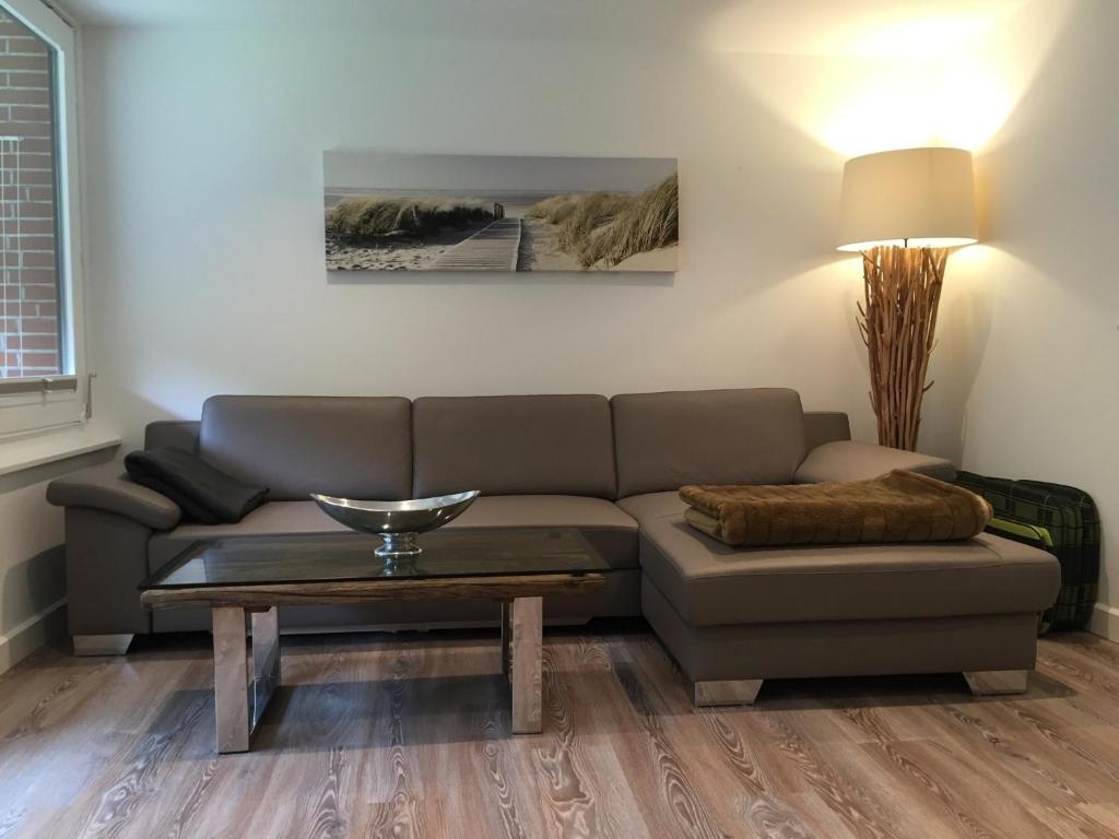 ein Wohnzimmer mit einem Sofa und einem Tisch in der Unterkunft Ferienwohnung Dünenblick in Westerland