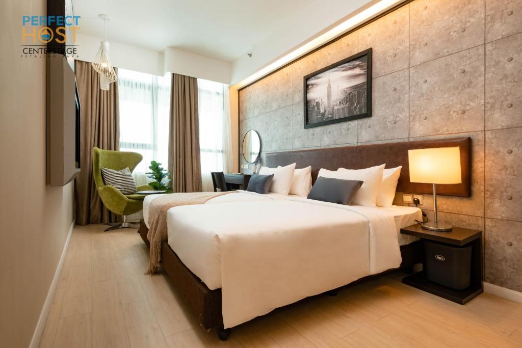 a hotel room with a large bed and a desk at Centrestage Petaling Jaya by Perfect Host in Petaling Jaya