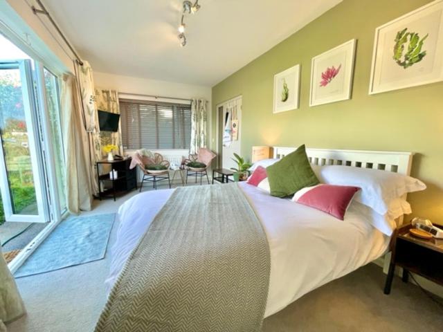 a bedroom with a large white bed with red pillows at Beautiful Garden Room with Private Entrance in Kingsbridge