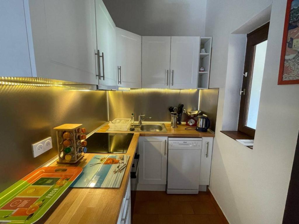 une petite cuisine avec des armoires blanches et un évier dans l'établissement Appartement 2 pièces avec piscine, tennis, clim, parking privé, proche plage - Argelès-sur-Mer - FR-1-225-683, à Argelès-sur-Mer