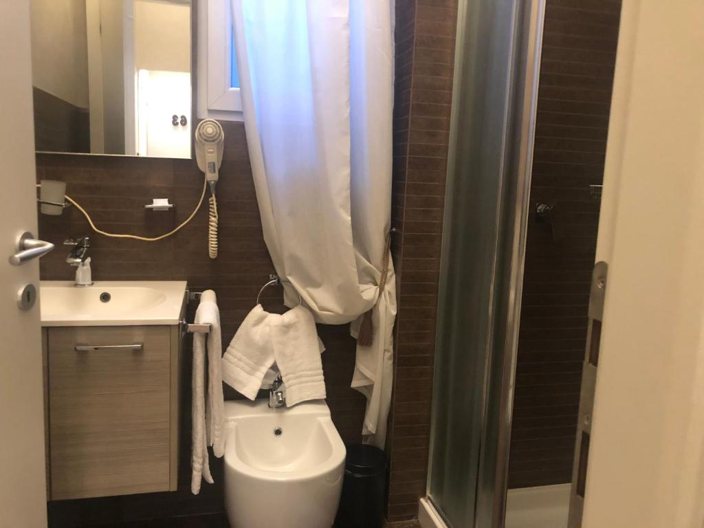 a bathroom with a toilet a sink and a shower at Linate Residence in Segrate