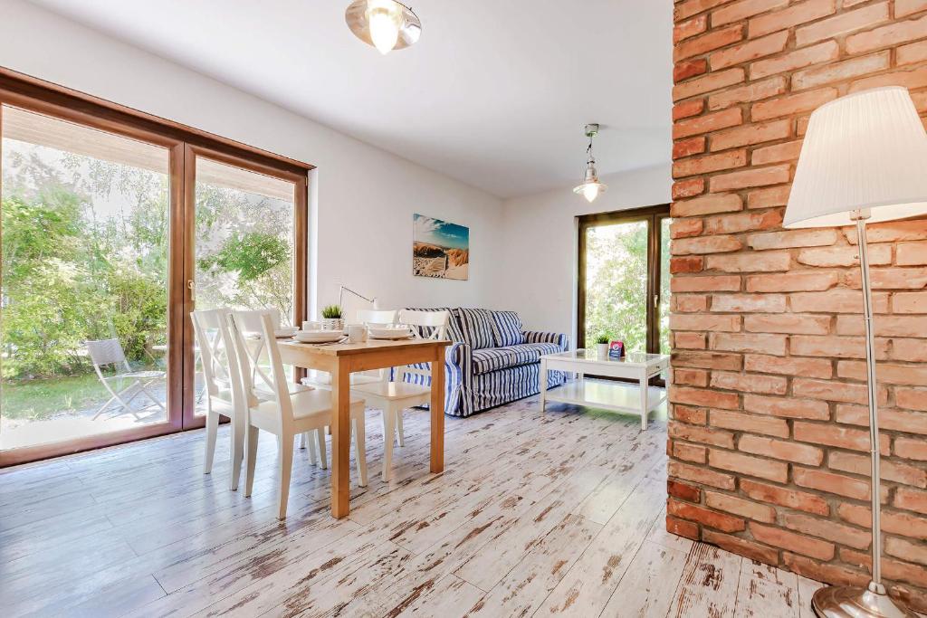 a dining room and living room with a brick wall at VacationClub - Plażowa 7 Apartament 2 in Gąski