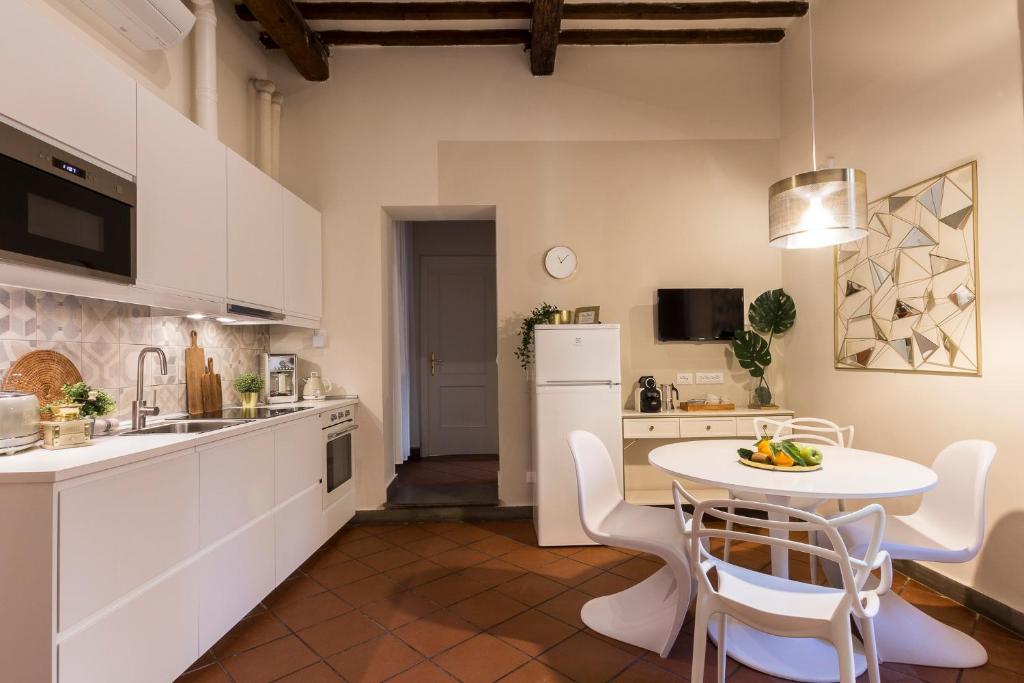 a kitchen with white cabinets and a table and chairs at Casa Dora in Florence