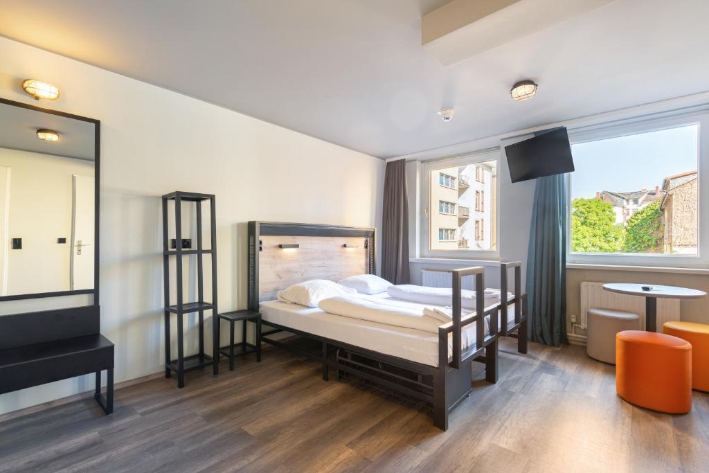 - une chambre avec un lit et une grande fenêtre dans l'établissement a&o Frankfurt Galluswarte, à Francfort-sur-le-Main